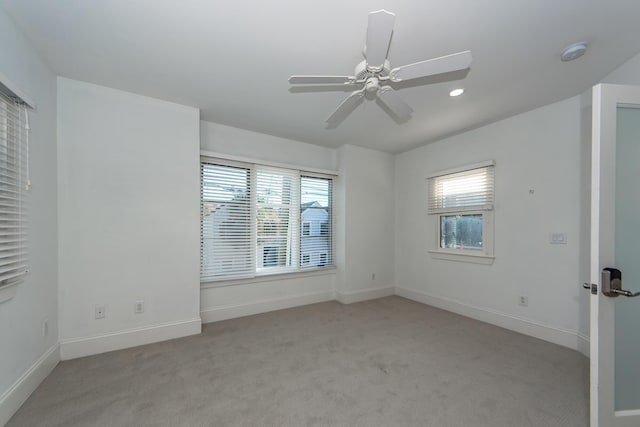 unfurnished room featuring ceiling fan and light carpet