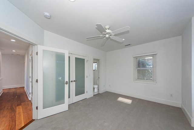 unfurnished bedroom with carpet floors, ensuite bathroom, french doors, and ceiling fan