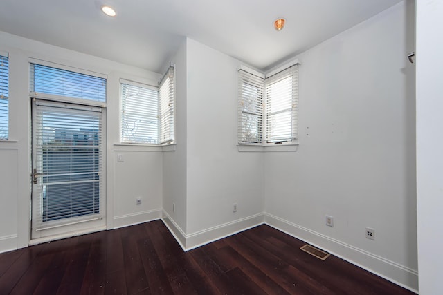 spare room with plenty of natural light and dark hardwood / wood-style floors