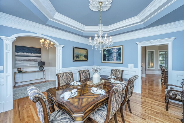 4233 Haulover Dr, Johns Island, SC 29455 - dining area featuring a chandelier, light wood-type flooring, ornamental molding, a raised ceiling, and wainscoting