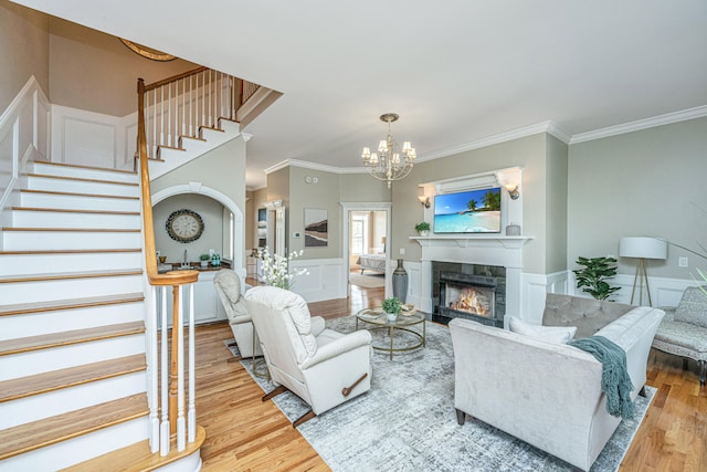 living room with crown molding, hardwood / wood-style flooring, and a notable chandelier