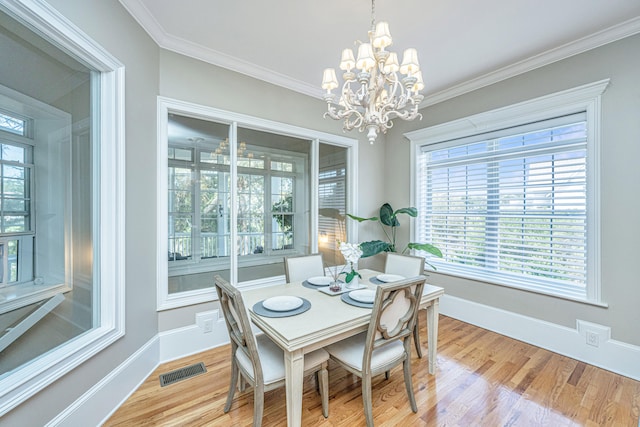 dining area featuring an inviting chandelier, crown molding, and light wood-type flooring