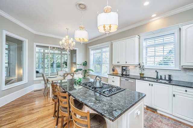 kitchen with white cabinets, decorative light fixtures, a healthy amount of sunlight, and sink