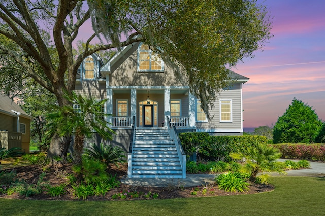 view of front of house with a porch and a lawn