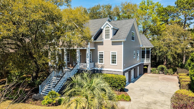 4233 Haulover Dr, Johns Island, SC 29455 - view of front facade featuring an attached garage, stairs, driveway, a shingled roof, and view of scattered trees