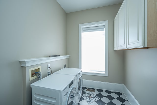 clothes washing area with washer and dryer and cabinets