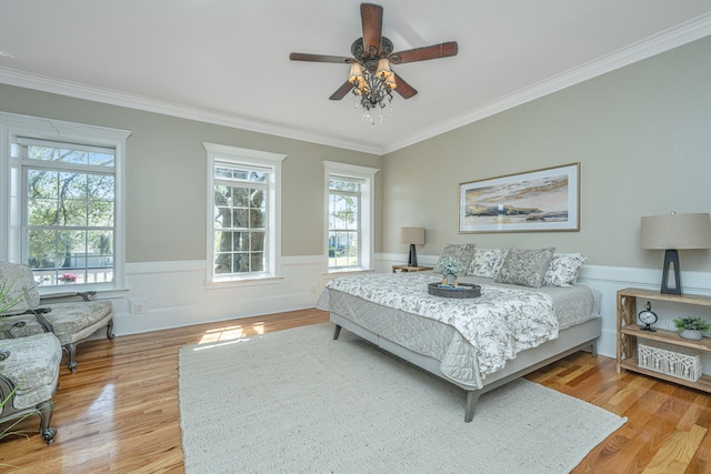 bedroom featuring ornamental molding, light wood-type flooring, and ceiling fan