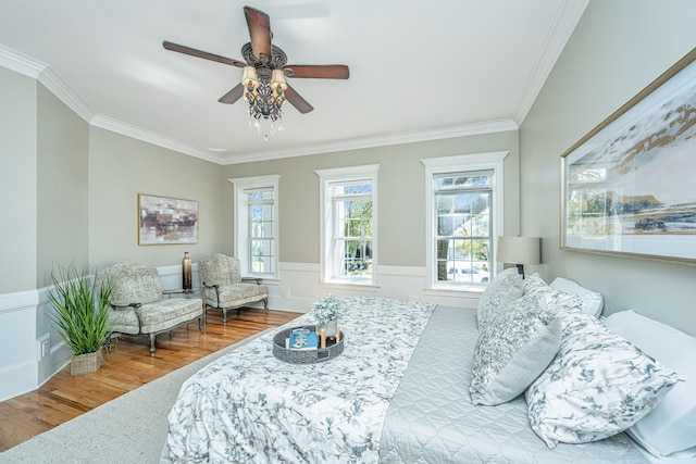 bedroom with ornamental molding, hardwood / wood-style floors, and ceiling fan