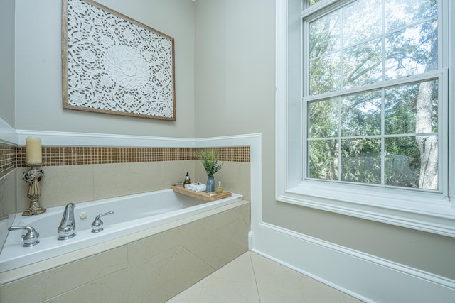 bathroom featuring a relaxing tiled tub, tile patterned floors, and a wealth of natural light