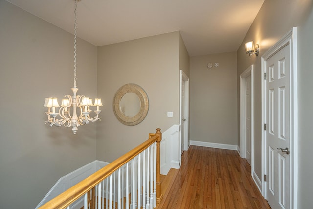 hallway featuring wood-type flooring and a chandelier