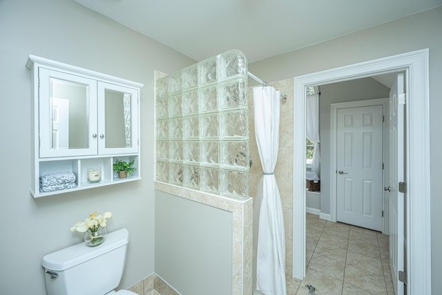 bathroom featuring toilet, walk in shower, and tile patterned floors