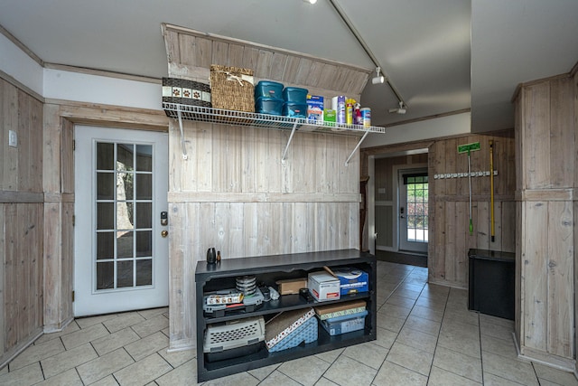 interior space featuring rail lighting and wood walls