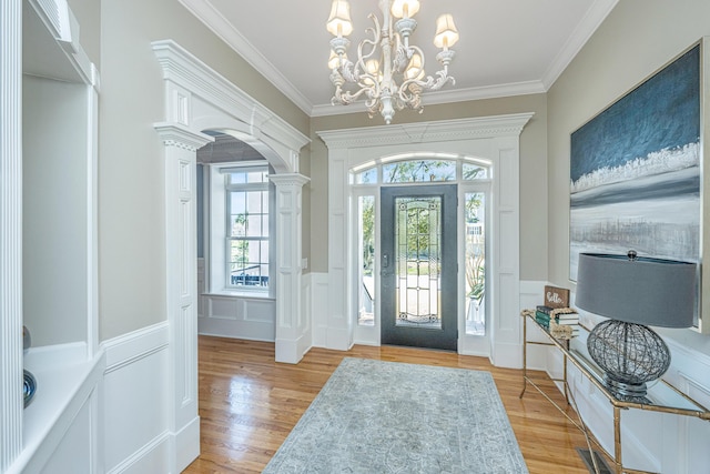 4233 Haulover Dr, Johns Island, SC 29455 - foyer entrance featuring a decorative wall, light wood finished floors, a wainscoted wall, a chandelier, and ornamental molding