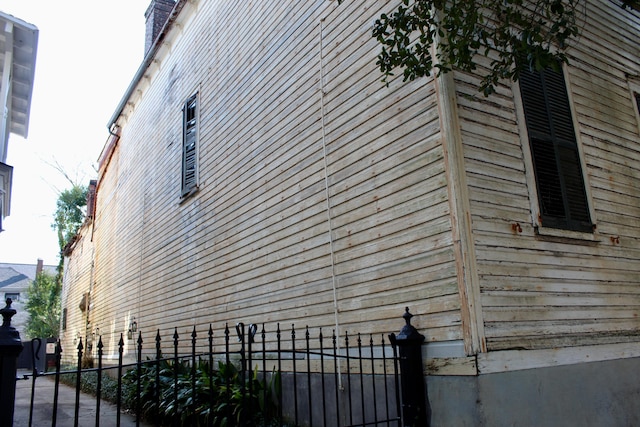 view of side of home featuring fence