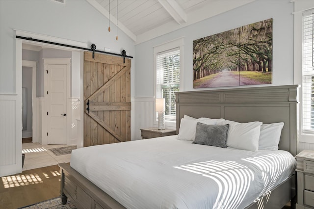 bedroom with hardwood / wood-style floors, a barn door, lofted ceiling with beams, and wood ceiling