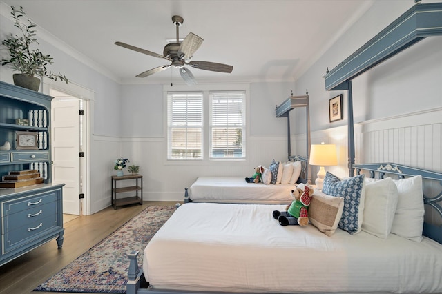 bedroom with wood-type flooring, ceiling fan, and crown molding