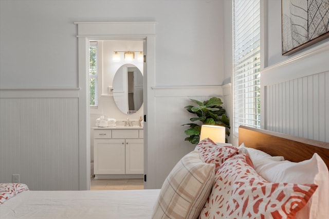 tiled bedroom featuring sink and connected bathroom