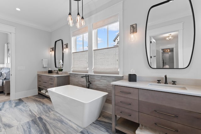 553 Old Compass Rd, Daniel Island, SC 29492 - bathroom featuring a freestanding bath, two vanities, ornamental molding, a chandelier, and baseboards