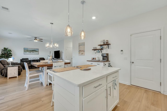 432 Eva St, Moncks Corner, SC 29461 - kitchen with white cabinetry, a center island, pendant lighting, light hardwood / wood-style floors, and ceiling fan with notable chandelier