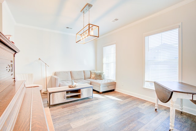 living room featuring crown molding, light hardwood / wood-style flooring, and a chandelier