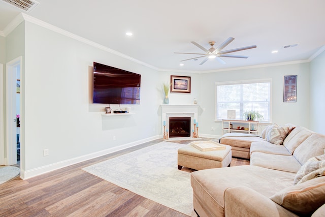 living room featuring ceiling fan, wood-type flooring, and ornamental molding