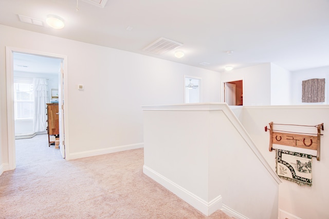 hall featuring light colored carpet