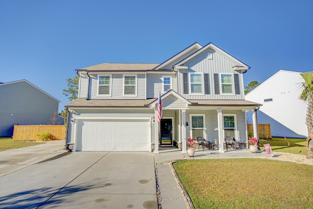 view of front of house featuring a front yard, a garage, and covered porch