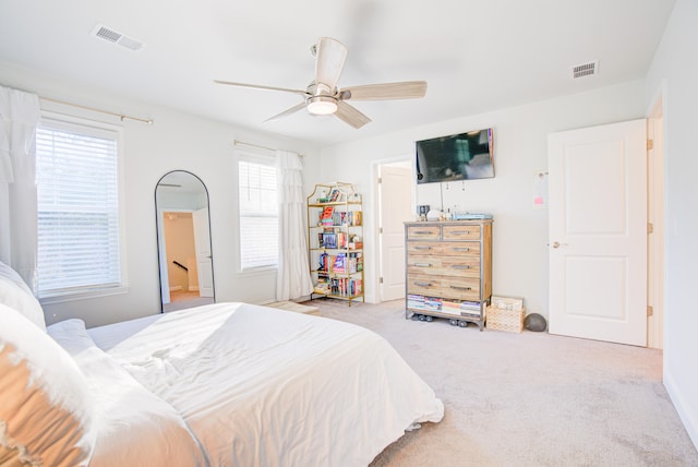 carpeted bedroom with multiple windows and ceiling fan