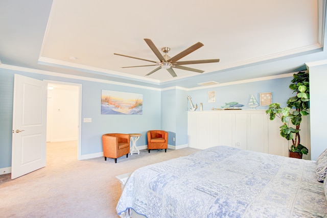 carpeted bedroom with ceiling fan, a raised ceiling, and crown molding