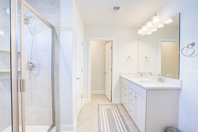 bathroom with tile patterned flooring, vanity, and a shower with door