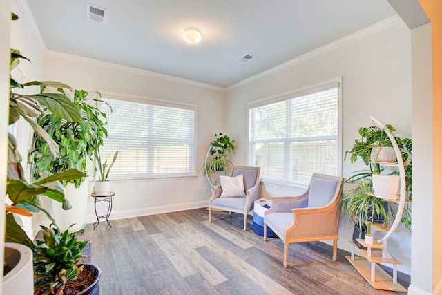 living area with wood-type flooring and ornamental molding