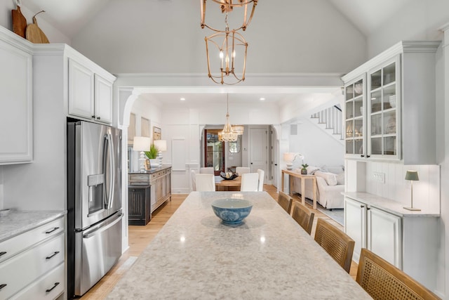 kitchen featuring white cabinetry, pendant lighting, a chandelier, and stainless steel fridge with ice dispenser