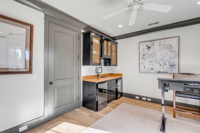 kitchen with sink, ceiling fan, black dishwasher, wood counters, and light wood-type flooring