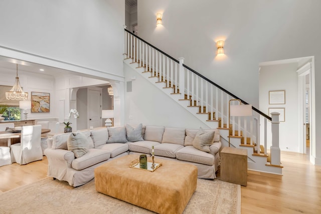 living room featuring a chandelier, hardwood / wood-style floors, and a high ceiling