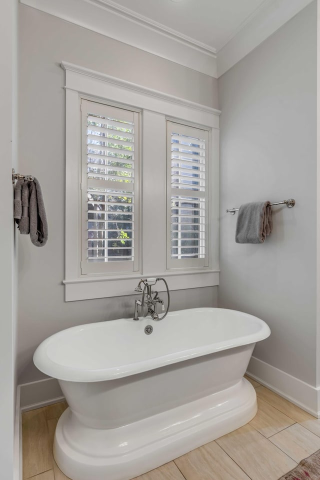 bathroom with ornamental molding and a bathtub