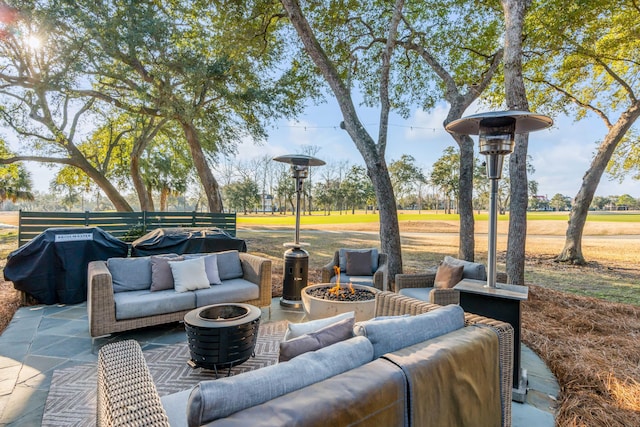 view of patio with area for grilling and an outdoor living space with a fire pit