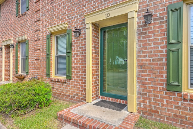 doorway to property with brick siding