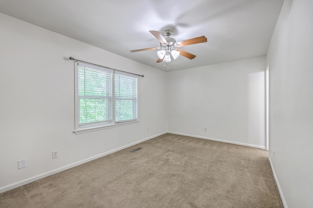 unfurnished room with a ceiling fan, carpet, and baseboards