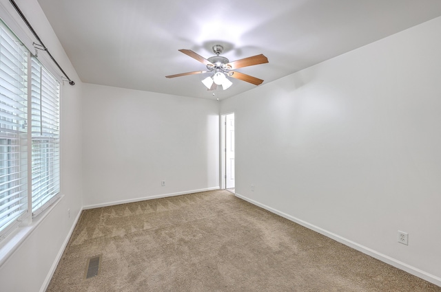 empty room featuring carpet flooring, ceiling fan, and baseboards