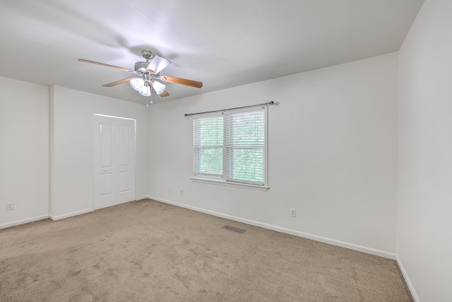 spare room with carpet floors, ceiling fan, and baseboards
