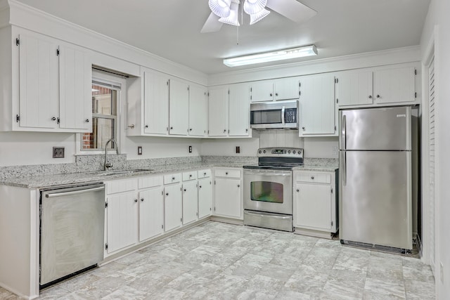 kitchen featuring appliances with stainless steel finishes, a sink, a ceiling fan, and light stone countertops