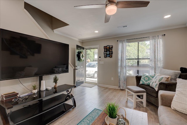living room featuring ceiling fan, light wood-style floors, baseboards, and ornamental molding