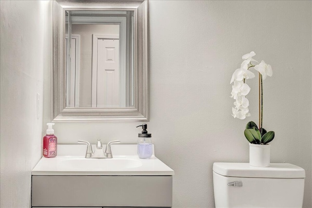 half bathroom with toilet and vanity