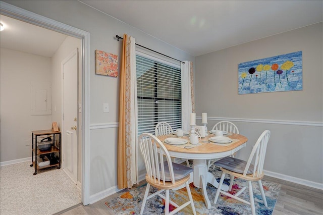 dining space with baseboards and wood finished floors