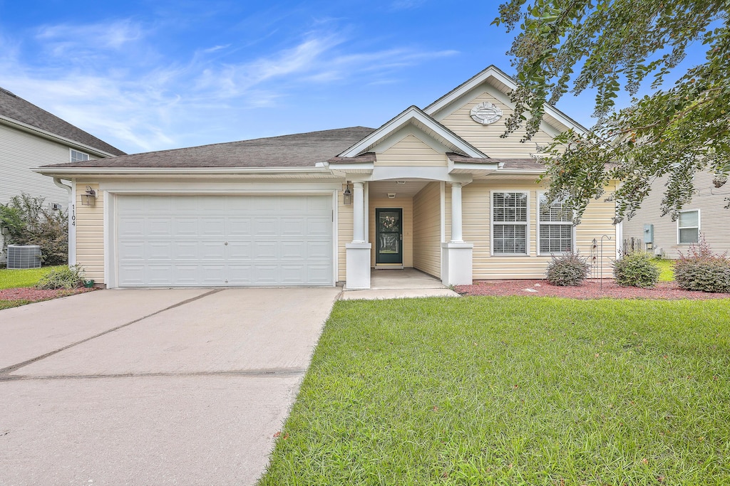 view of front of property featuring a garage, central air condition unit, and a front yard