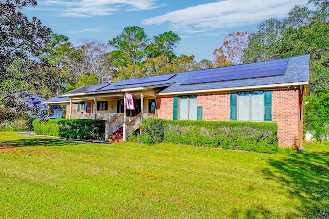 ranch-style home with solar panels, a porch, and a front lawn