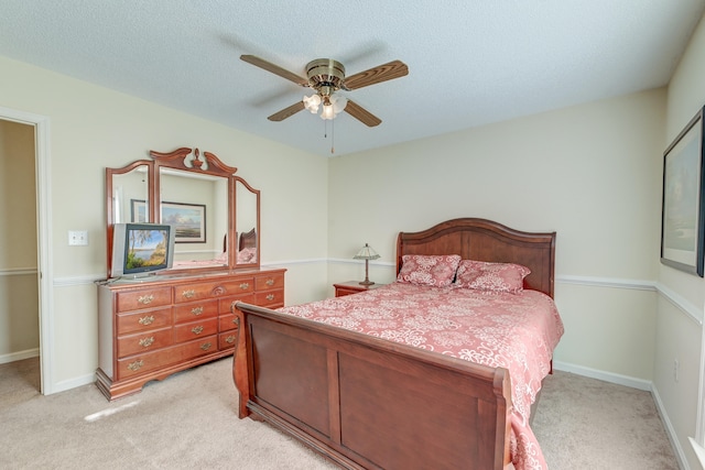 carpeted bedroom with ceiling fan and a textured ceiling