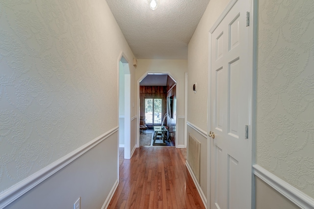 hallway featuring wood-type flooring and a textured ceiling