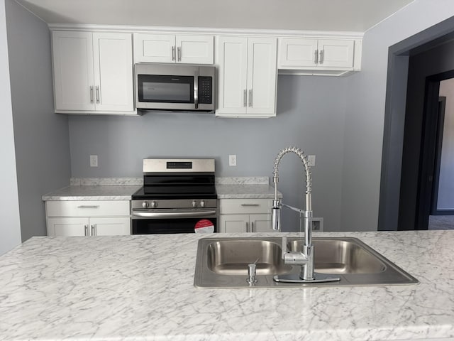 109 NW Haddock Rd, Orangeburg, SC 29115 - kitchen with appliances with stainless steel finishes, a sink, and white cabinetry