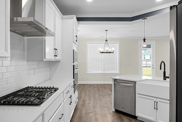 661 Black Pine Rd, Moncks Corner, SC 29461 - kitchen with wall chimney range hood, stainless steel appliances, crown molding, dark wood-type flooring, and light countertops